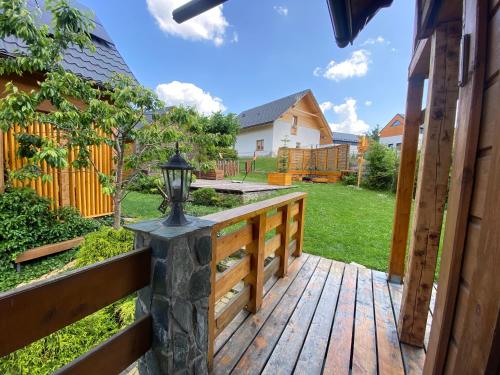 a wooden deck with a gate and a fence at Babie Domki in Zawoja
