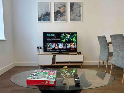 a living room with a tv and a glass table at New Build 2 Bedroom Luxury Apartment, Jewellery Quarter Birmingham in Birmingham