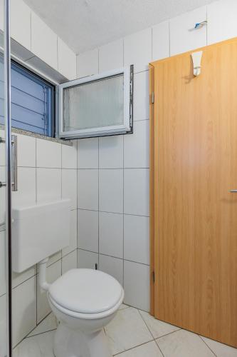 a bathroom with a toilet and a wooden door at Traditional holiday house by the sea in Preko
