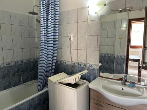 a bathroom with a sink and a toilet and a tub at M35 4s Debrecen Apartman in Debrecen