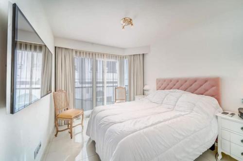une chambre blanche avec un grand lit et une fenêtre dans l'établissement PACA Properties 7C2 - appartement 3 chambres, à Cannes
