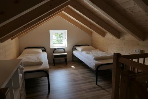 2 Betten in einem Dachzimmer mit Fenster in der Unterkunft Casa Safra in Kötschach