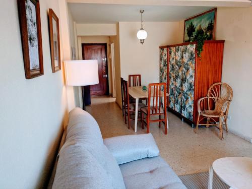 ein Wohnzimmer mit einem Sofa, einem Tisch und Stühlen in der Unterkunft Chambre de Molina in Málaga