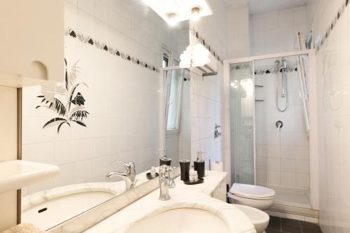 y baño blanco con aseo y ducha. en Chiara´s apartment porta Vittoria en Milán