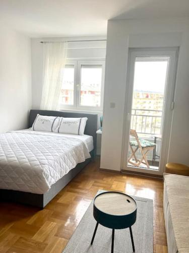 a bedroom with a bed and a table in it at Studio Pao in Podgorica