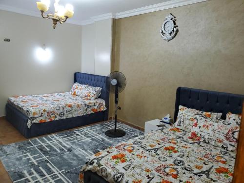 - une chambre avec 2 lits et une lampe dans l'établissement Mena Apartment, au Caire