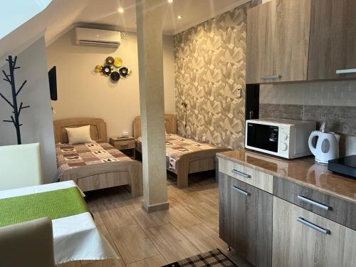 a kitchen with two beds and a microwave on a counter at Silver Apartman in Eger