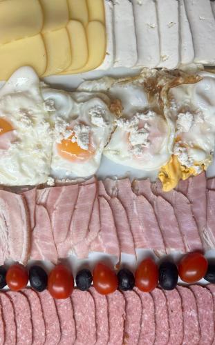 a cake with eggs and tomatoes on top of it at Pensiunea Deceneu in Slănic