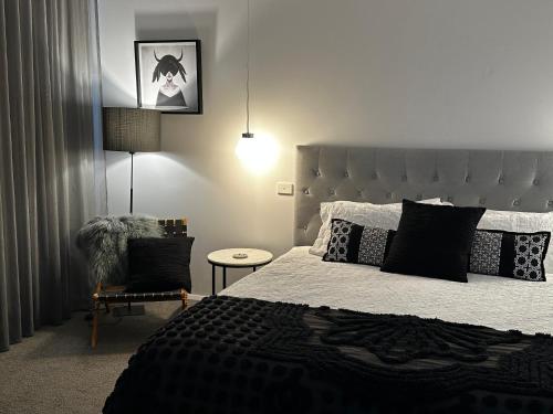 a bedroom with a large bed and a chair at Tranquilo Daylesford in Daylesford