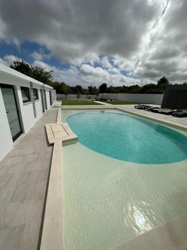 a large swimming pool next to a white building at 145 Townhouse in Ílhavo