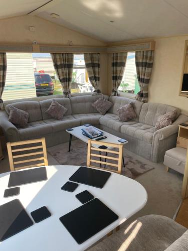 a living room with a couch and a table and chairs at Ingoldmells, Coral beach, 8 birth in Ingoldmells