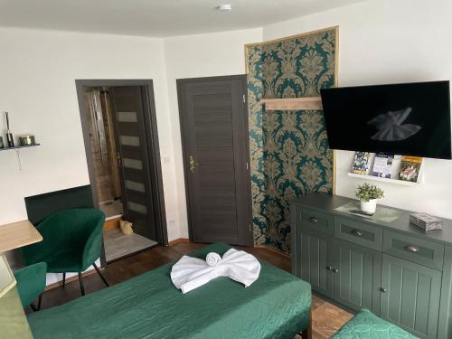 a bedroom with a green bed with a bow on it at Ubytování U Synagogy Dobříš in Dobříš