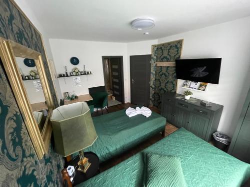 a bedroom with two green beds and a desk at Ubytování U Synagogy Dobříš in Dobříš