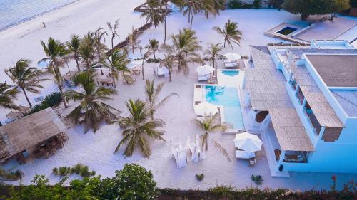 an aerial view of a resort with a pool and palm trees at Simba Wa Kale Suites & Beach in Watamu