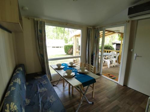 a small room with a table and a dining room at Mobile Home ~ Parc des Roches in Saint-Chéron
