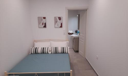 Un pequeño dormitorio con una cama azul en una habitación en Cosy Studio for couples 2 min from Mades Beach, en Ligaria