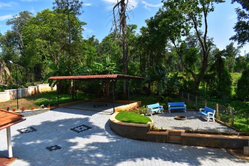 un patio con cenador y 2 sillas azules en Rochas Valley Homestay, en Suntikoppa