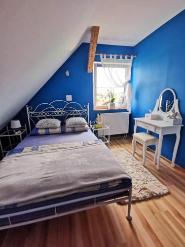 a blue bedroom with a bed and a desk at Widok na Śnieżkę in Miłków