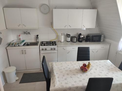 a kitchen with a table with a bowl of fruit on it at Veronika Rooms in Hévíz