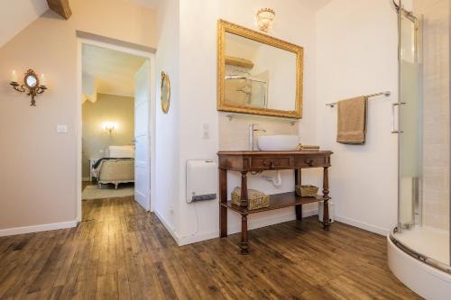 a bathroom with a sink and a mirror on the wall at Villa Verte in Saint-Mathieu