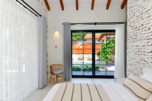 a bedroom with a white bed and a brick wall at Sojoy Villa Allure in Fethiye
