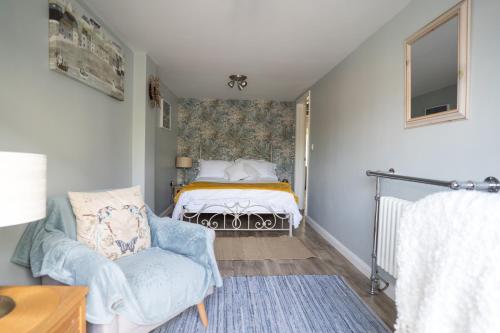 a small bedroom with a bed and a chair at Driftwood by the Sea in Brighton & Hove