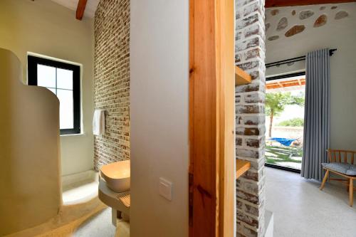 een badkamer met een wastafel en een bakstenen muur bij Sojoy Villa Allure in Fethiye