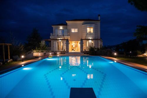 a swimming pool in front of a house at night at Villa San Adriano in Nafplio