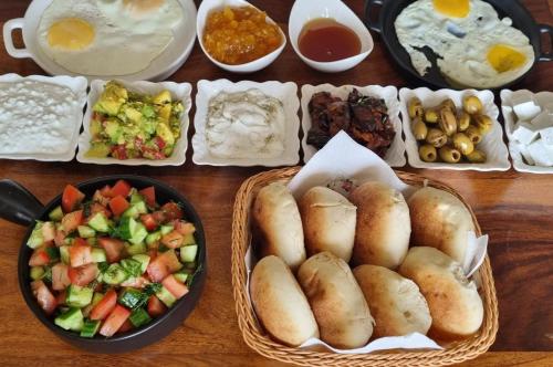 a table full of food with buns and a bowl of vegetables at Suite Kolibri in Galilee in Semadar
