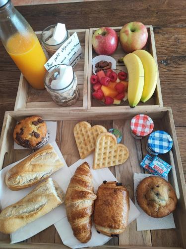 een houten dienblad met verschillende soorten brood en fruit bij L'étincelle secrète - gîte romantique entre cordes et Najac in Le Ségur-Suech
