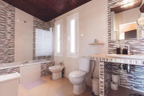 La salle de bains blanche est pourvue de toilettes et d'un lavabo. dans l'établissement Tranquil House Perfect for Vacations, à el Mas Vila