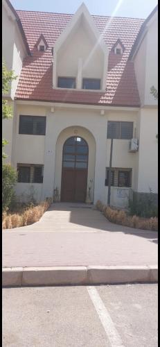 Una casa blanca con una puerta marrón y una entrada. en IFRANE, en Ifrane