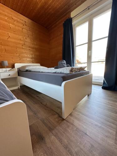 ein Schlafzimmer mit einem großen Bett in einem Zimmer mit Holzwänden in der Unterkunft Ferienhaus Abendfrieden in Mittenwald