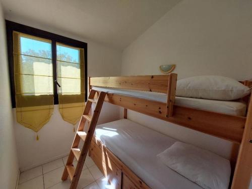 une chambre avec deux lits superposés et une fenêtre dans l'établissement T3 climatisé vue mer piscine tennis, à Grosseto-Prugna