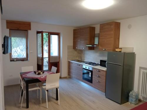 a kitchen with a dining table and a refrigerator at Maison Loren Pila in Cerise