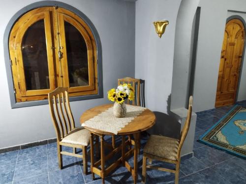 盧克索的住宿－Gabawy Garden Ferienwohnung，餐桌、椅子和花瓶
