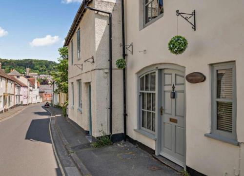 a street with a white building with a door at Carpenters Cottage Quirky home Seaside town in Minehead