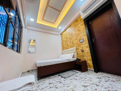 um pequeno quarto com uma cama e uma porta em The Bella Guesthouse em Varanasi