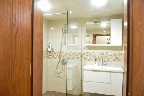 a bathroom with a shower and a sink and a mirror at Trimaya apartment - comfort in the top city center in Varna City