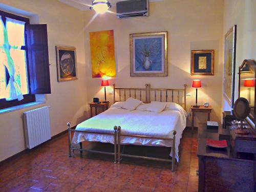 a bedroom with a bed and two tables and two lamps at Villa Giardini in Capoterra
