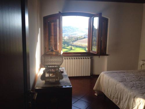 een slaapkamer met een bed en een raam met uitzicht bij Charming Villa in Monferrato in Camino