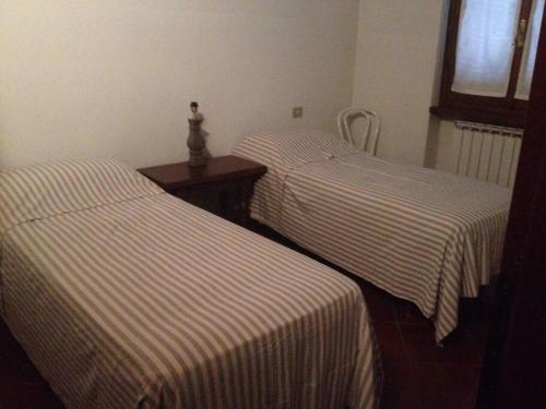 2 Betten mit gestreifter Bettwäsche in einem Zimmer in der Unterkunft Charming Villa in Monferrato in Camino