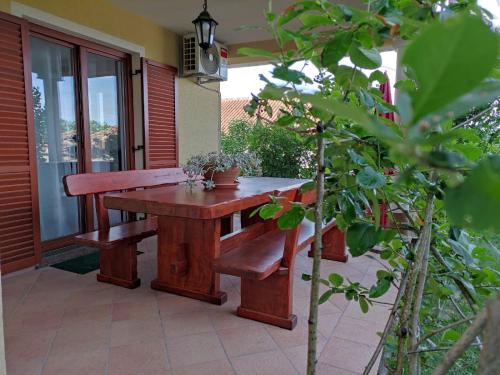 a wooden table and benches on a patio at Apartman Roža in Matulji