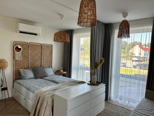 a bedroom with a bed and a large window at Nida, Vėtrungių 7 apartamentai prie marių in Nida