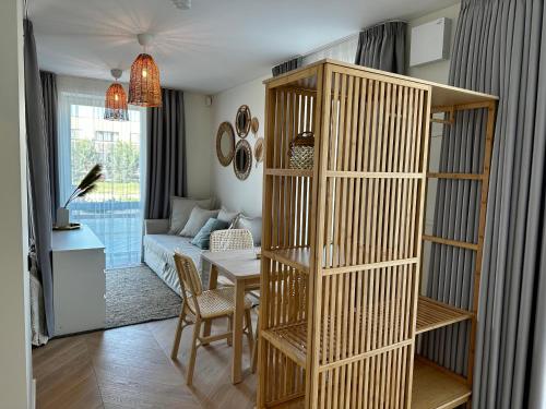 a living room with a book shelf and a table at Nida, Vėtrungių 7 apartamentai prie marių in Nida