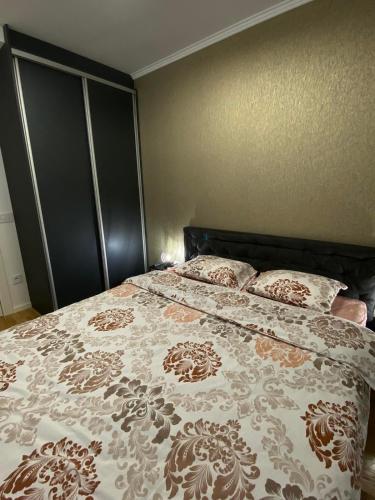 a bedroom with a bed with a brown and white bedspread at Bozur/peony in Pasuljište