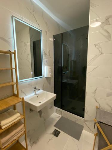 a white bathroom with a sink and a shower at Bozur/peony in Pasuljište