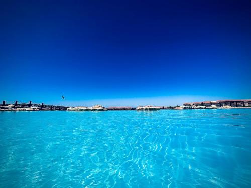 een grote hoeveelheid blauw water met gebouwen op de achtergrond bij Telal Al Sukhna Only families in Ain Sokhna