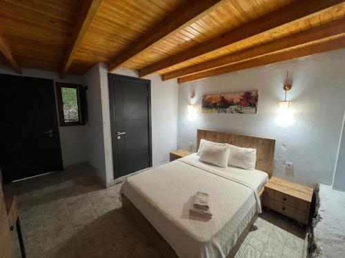 a bedroom with a large bed and a wooden ceiling at Ados Hotel in Cesme