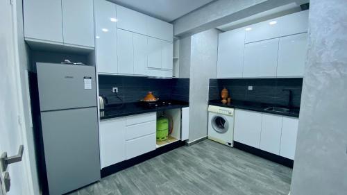 a kitchen with white cabinets and a washer and dryer at Big appartment near soccer stadium in Tangier in Tangier